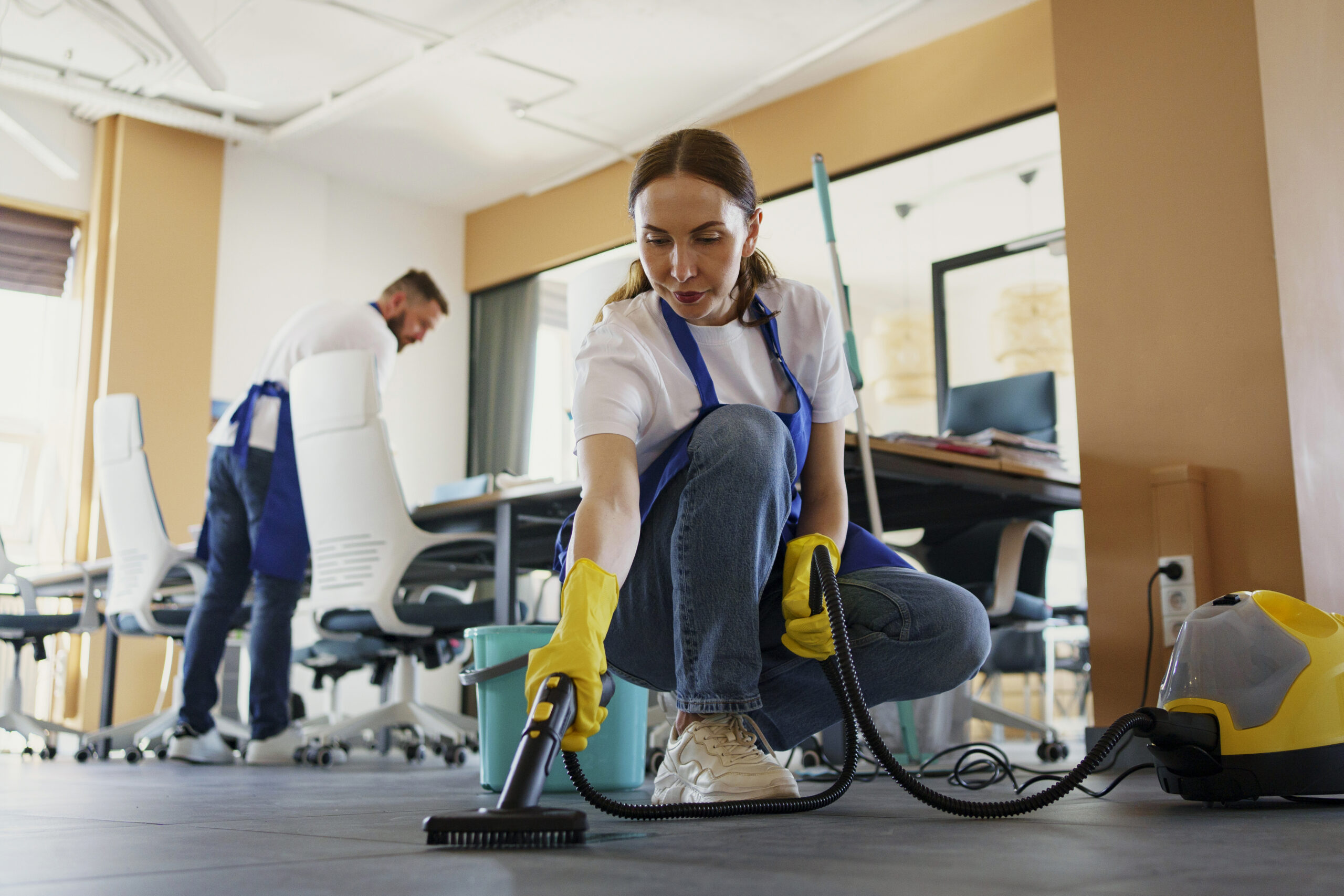 professional cleaning service person using vacuum cleaner office