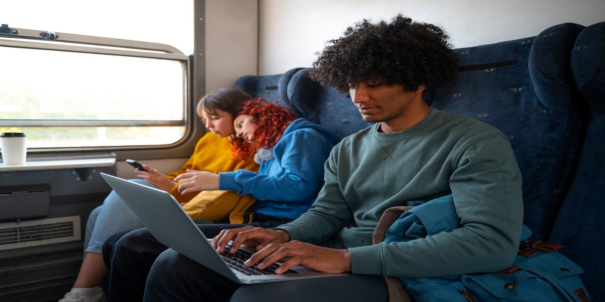Passageiros utilizando notebook em uma viagem de trem